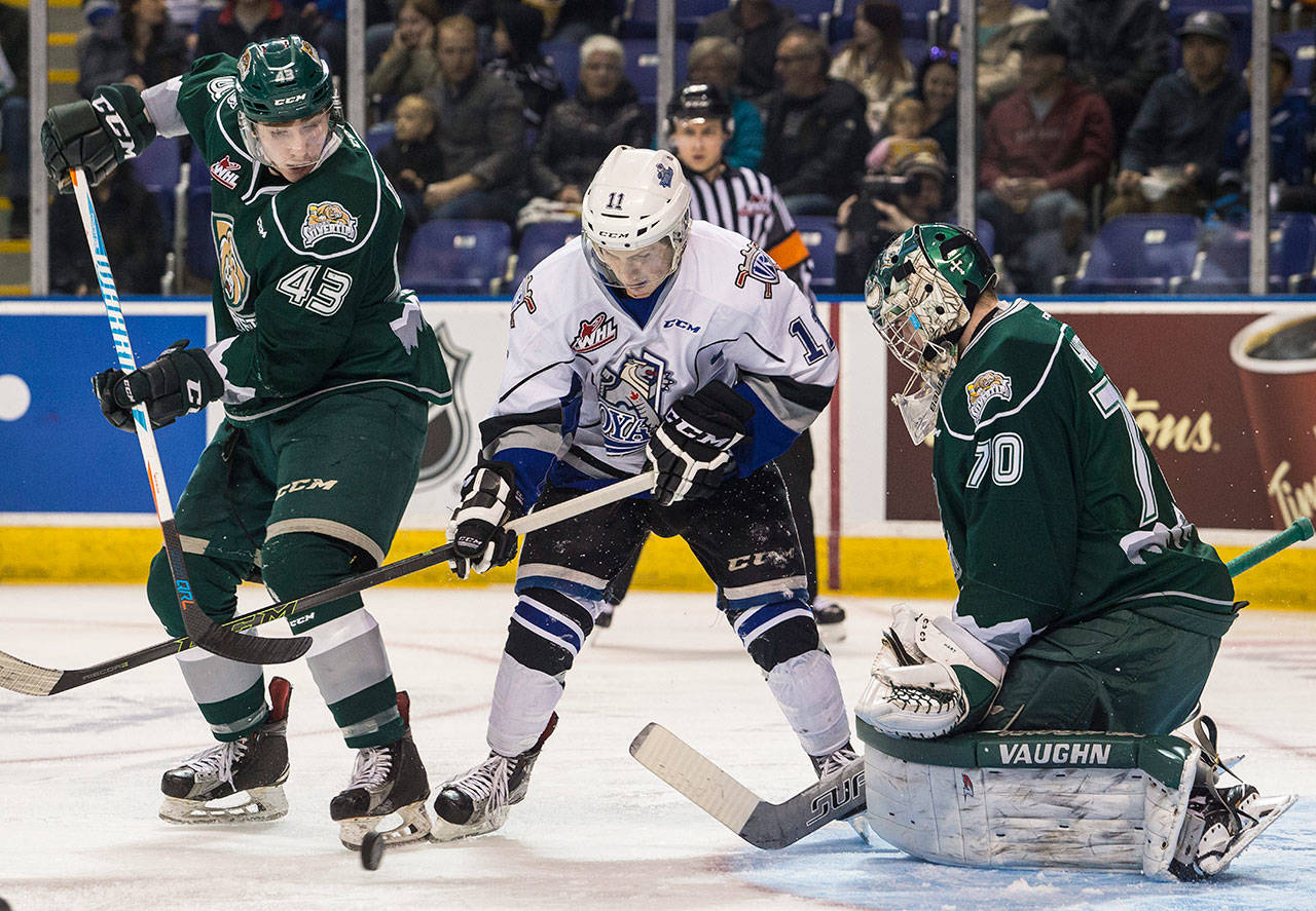 The Royals’ Matthew Phillips (center) looks for a shot as the Silvertips’ Connor Dewar (left) and Carter Hart defend during a playoff game on March 29, 2017, in Victoria, B.C. (Darren Stone / Times Colonist)