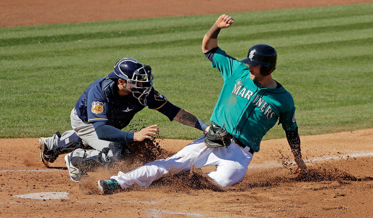 Mariners’ Mitch Haniger is tagged out at home by Milwaukee Brewers catcher Manny Pina in the second inning of a spring training baseball game Thursday in Peoria, Ariz. (AP Photo/Charlie Riedel)
