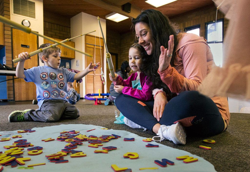 Anna Datko (right) and her 3-year-old daughter, Emma Datko, fish for magnetized letters during Ready Readers: Toddler Storytime hosted by the Lake Stevens Library at the neighboring Community Center on Tuesday. The library utilizes the large space in the community center for events and readings. (Daniella Beccaria / The Herald)
