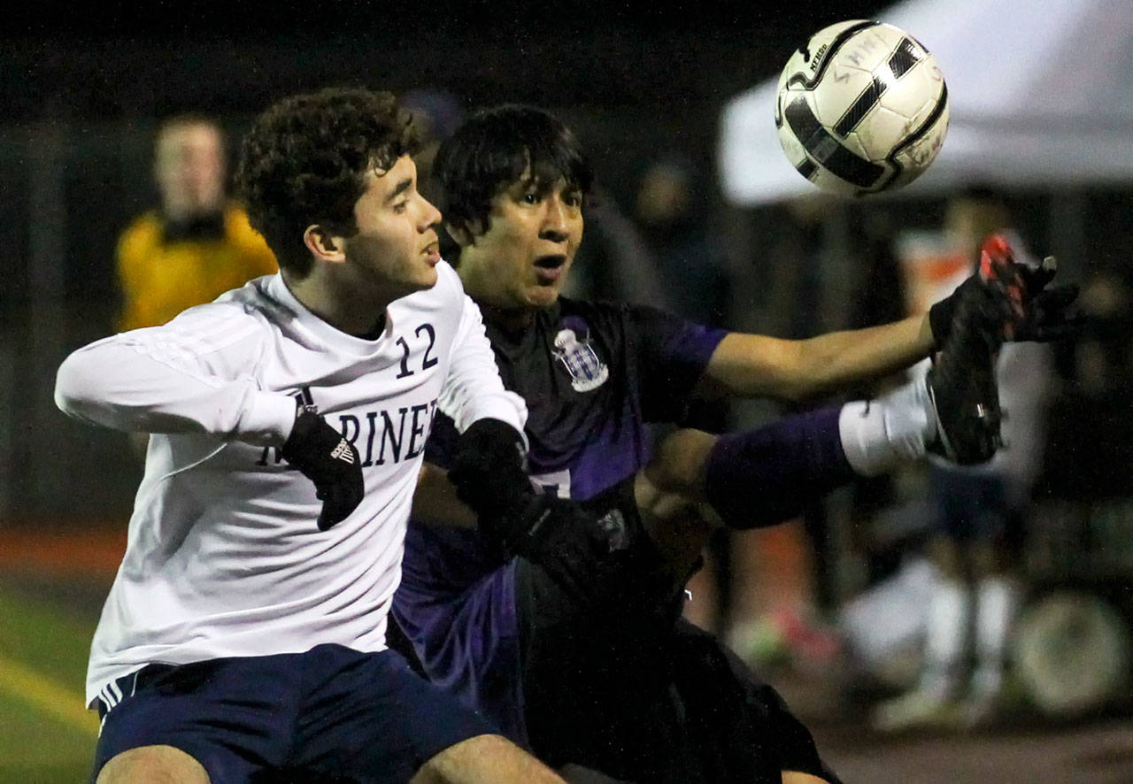Mariner’s Raoul Trejo, left, and Kamiak’s Manuel Segura vie for control a loose ball in the first half Friday night at Mariner High on March 24, 2017. (Kevin Clark / The Herald)