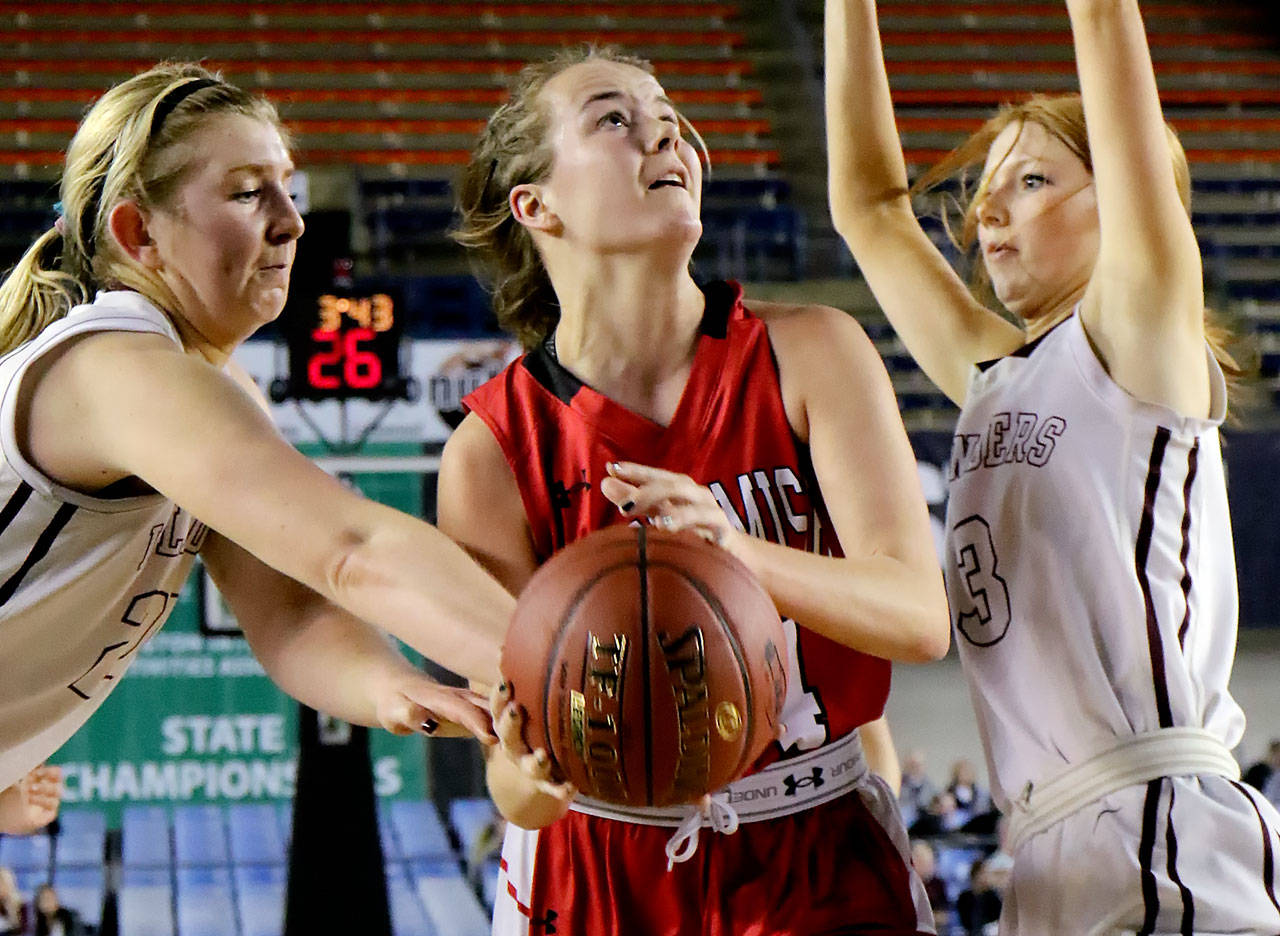 Snohomish’s Kyra Beckman (center) goes up for a shot with Mercer Island’s Anna Luce (left) and Jessie Stenberg defending during a 3A Hardwood Classic semifinal game Friday at the Tacoma Dome. Snohomish lost to Mercer Island 60-51. (Kevin Clark / The Herald)