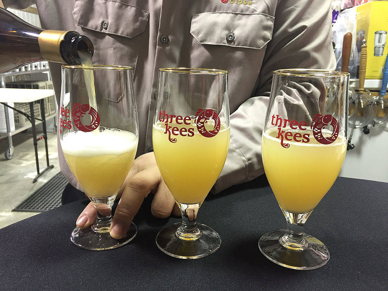 Roger Kee, co-owner of Three Kees Cidery, pours three glasses of sparkling cider. The grand opening of The new Snohomish cidery celebrates its grand opening today, April 1. (Aaron Swaney photo)