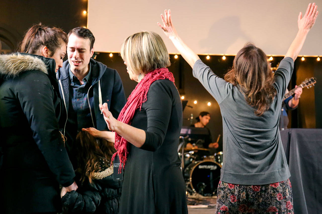 Amethyst Goad (from left), with daughter Farah Pishue, is prayed over by Pastor Russell Johnson and his mother, Anna Johnson, with Richelle Walker (right) rejoicing March 12 at The Pursuit NW in Snohomish. (Kevin Clark / The Herald)