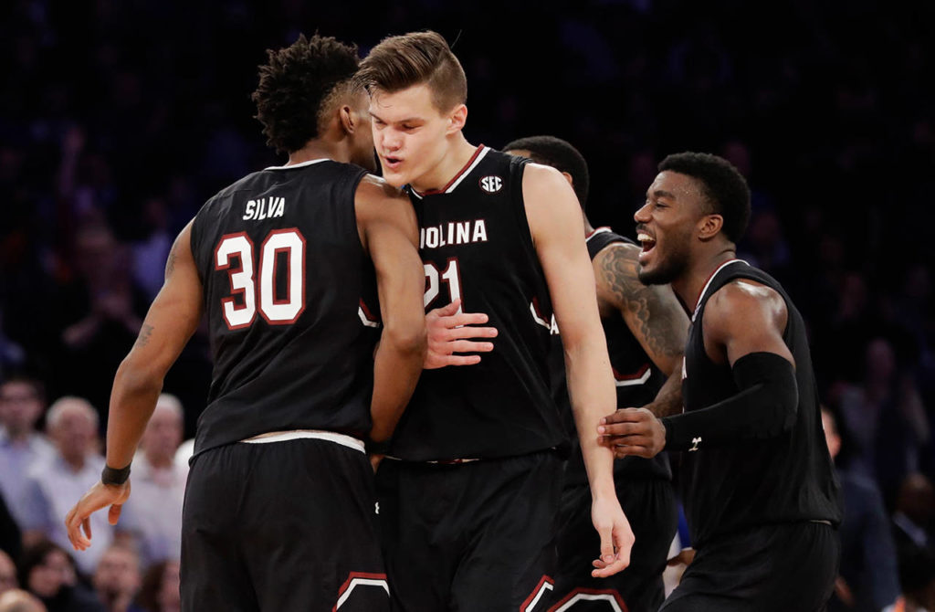 South Carolina forward Maik Kotsar (21) is congratulated by forward Chris Silva (30) after scoring against Florida during the second half of the East Regional championship game of the NCAA men’s college basketball tournament, Sunday, March 26, in New York. (AP Photo/Julio Cortez)
