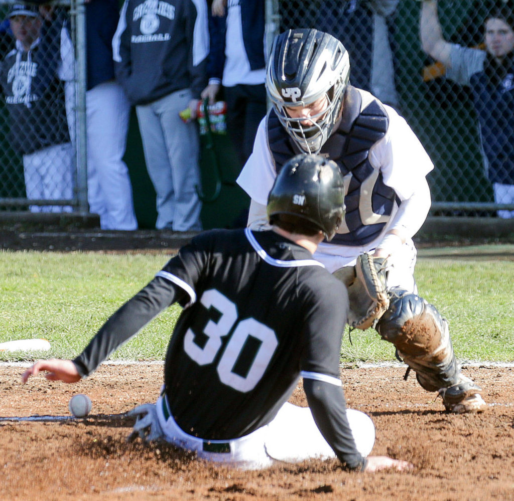 Jackson’s Carter Booth beats the throw home with Glacier Peak catcher Nate Sanders defending the plate during a game on March 30, 2017, at Jackson High School in Mill Creek. (Kevin Clark / The Herald)
