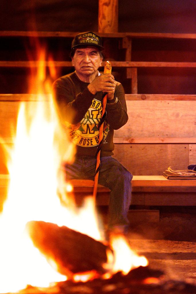 In the Tulalip Tribes’ sacred long house on Tulalip Bay in April 1999, Raymond Moses prepares a warm fire before meeting with youngsters from Pinewood Elementary School in Marysville. (Dan Bates / Herald file)
