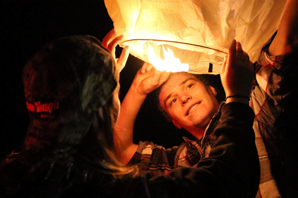 Hailey Norris and Zach Brunner work to launch a lantern. (Kevin Clark / The Herald)
