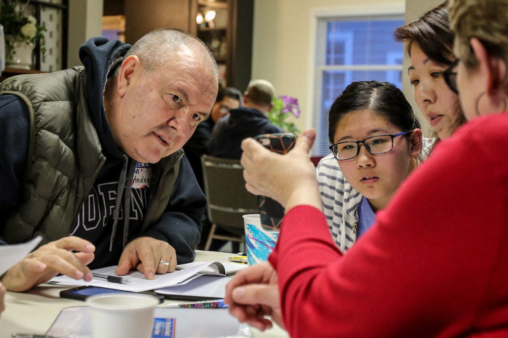 Andrey Matveev (from left), Kathy Yu and Susan Yu look over examples. (Kevin Clark / The Herald)
