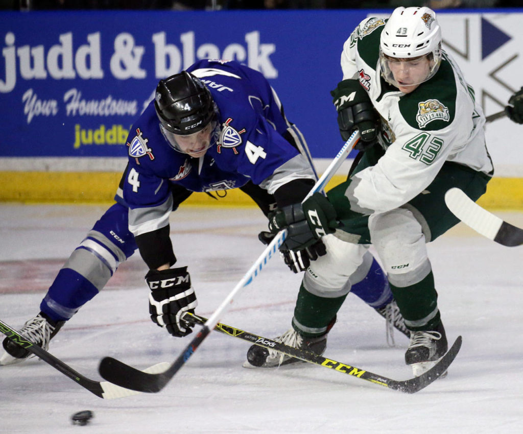 Victoria’s Ralph Jarratt (left) and Everett’s Connor Dewar chase down a loose puck in the second period of a playoff game on March 25, 2017, at Xfinity Arena in Everett. (Kevin Clark / The Herald)
