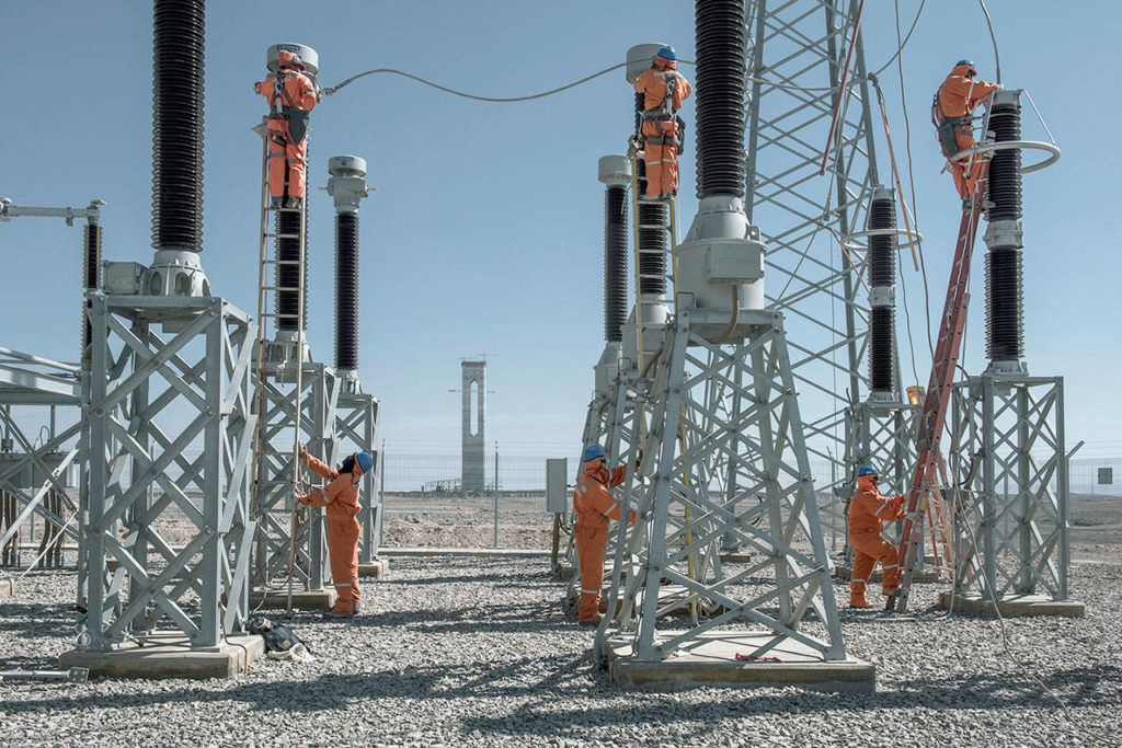 Local workers clean insulators at the Cerro Dominador solar plant’s booster substation. The substation raises the voltage to the 220 kv needed to connect to the grid. (Photo by Tamara Merino for The Washington Post)
