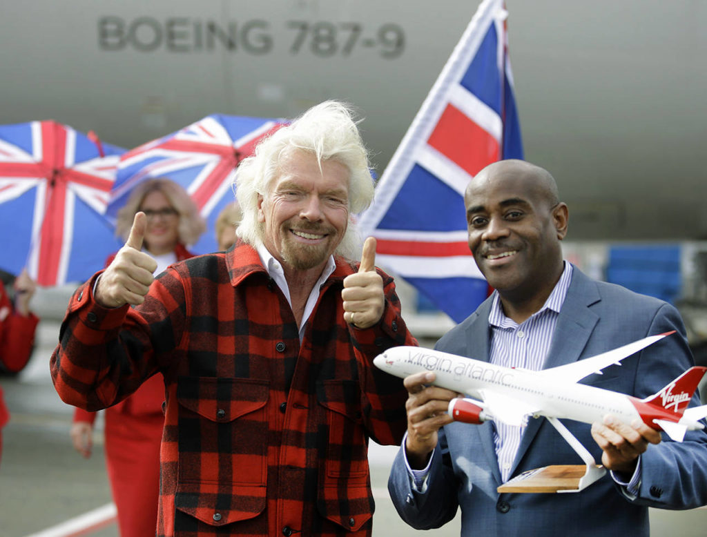 Richard Branson reacts after presenting Lance Lyttle, Managing Director of the Port of Seattle, with a model airplane after Branson arrived on a flight from London to Seattle on Monday at Sea-Tac Airport. (AP Photo/Ted S. Warren)
