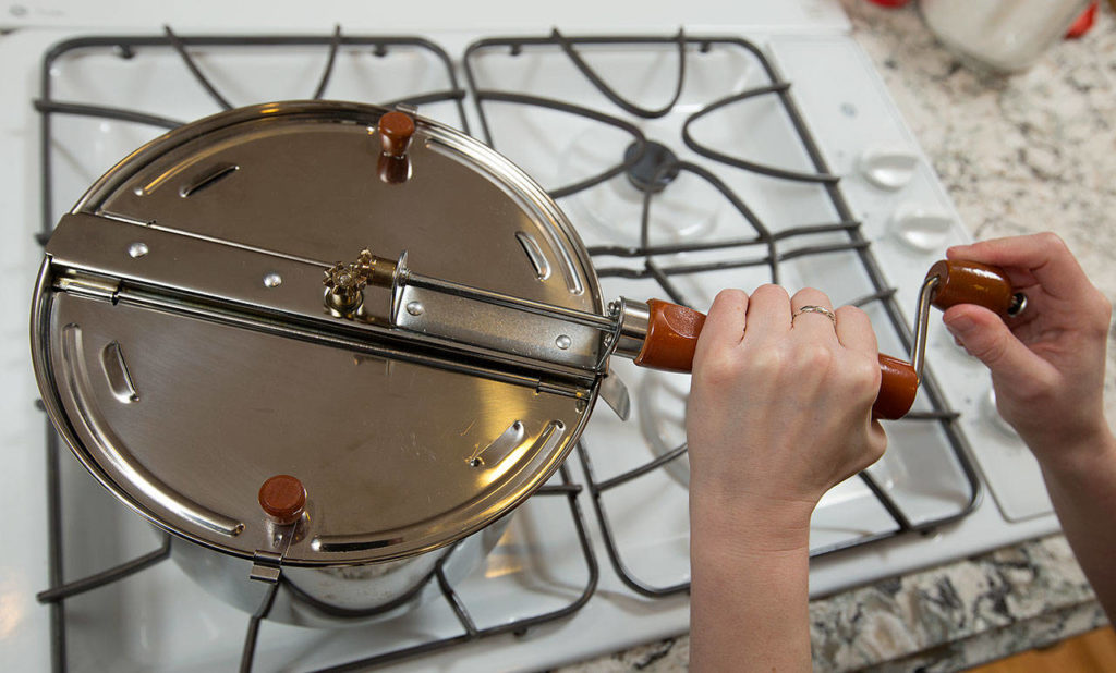 Make popcorn using a crank and a gas stove. (Andy Bronson / The Herald)
