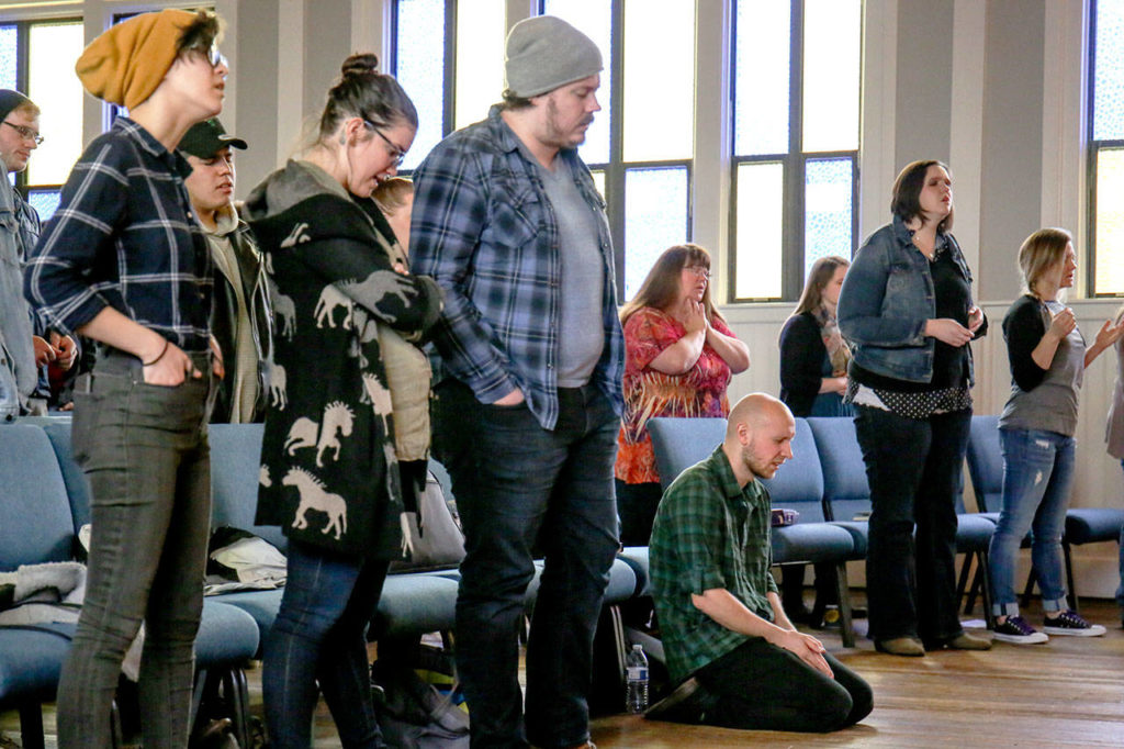 Charles Link kneels in prayer in the closing minutes of service. (Kevin Clark / The Herald)
