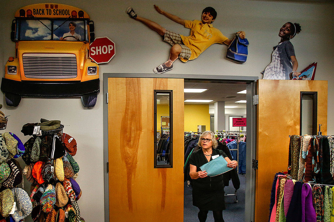 Providing more than the expected: Diane Pedack works with the childrens’ clothes inventory at Operation School Bell, which includes a wonderful selection of fine hand-knitted hats and scarfs. (Dan Bates / The Herald)