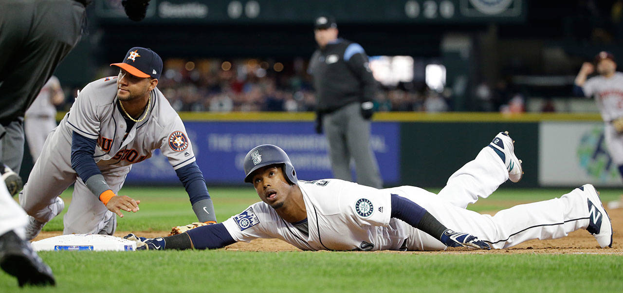 Seattle’s Jean Segura, right, and Houston first baseman Yuli Gurriel look up for the call after Segura dove back to first base on a line drive by Mitch Haniger in the third inning of Monday’s game at Safeco Field. Segura was out on the play. (AP Photo/Elaine Thompson)