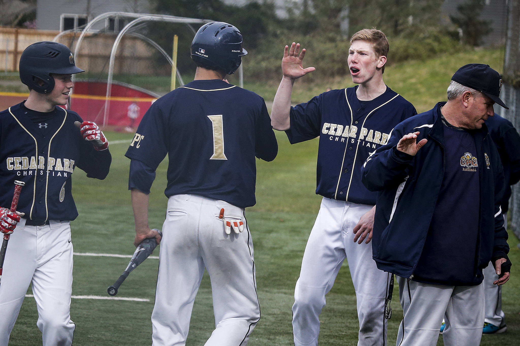 Cedar Park Christian’s George Reidy (right) congratulates teammate Michael Attalah (center) after scoring during a game against Archbishop Murphy on April 11, 2017, at Archbishop Murphy High School in Everett. (Ian Terry / The Herald)
