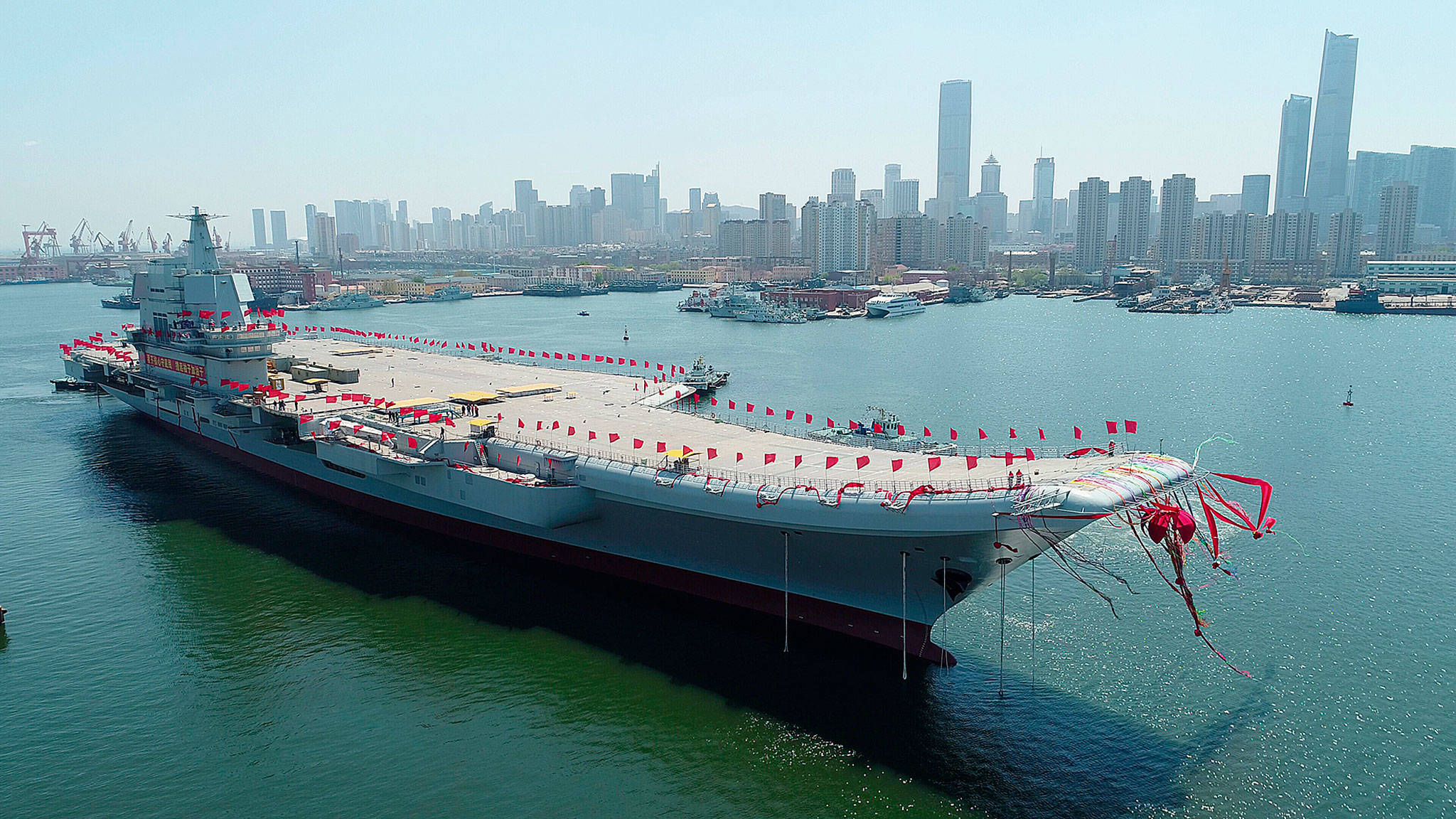 A new aircraft carrier is transferred from dry dock into the water in Dalian, China, on Wednesday. (Li Gang/Xinhua)