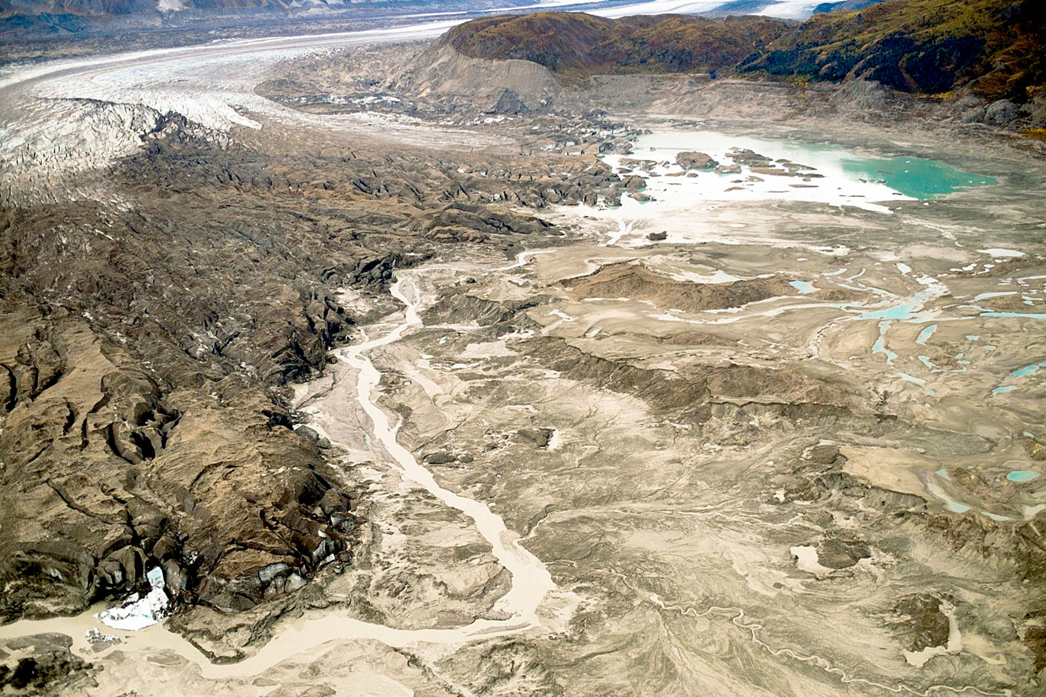 A stream runs along the toe of the Kaskawulsh glacier in Canada. In 2016, this channel allowed the glacier’s meltwater to drain in a different direction than normal, resulting in Slims River water being rerouted to a different river system. (Dan Shugar)