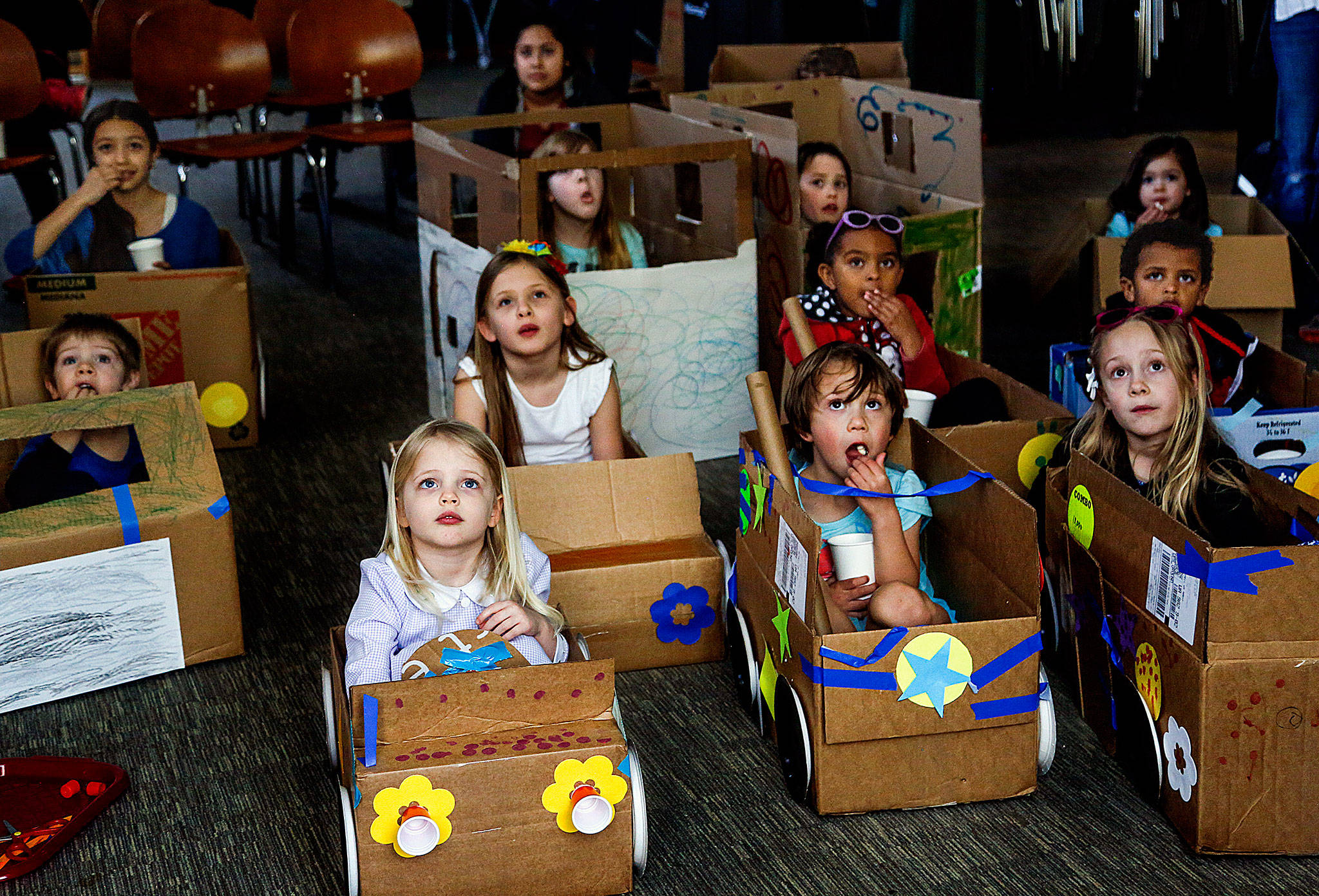 Snohomish area children enjoy watching movies Monday afternoon at the Snohomish Library’s “My First Drive-in” event. The youngsters, 3 years and older, brought cardboard boxes from home and used their arts and crafts skills to transform them into pretend cars to sit in while watching a selection of movie shorts. (Dan Bates / The Herald)