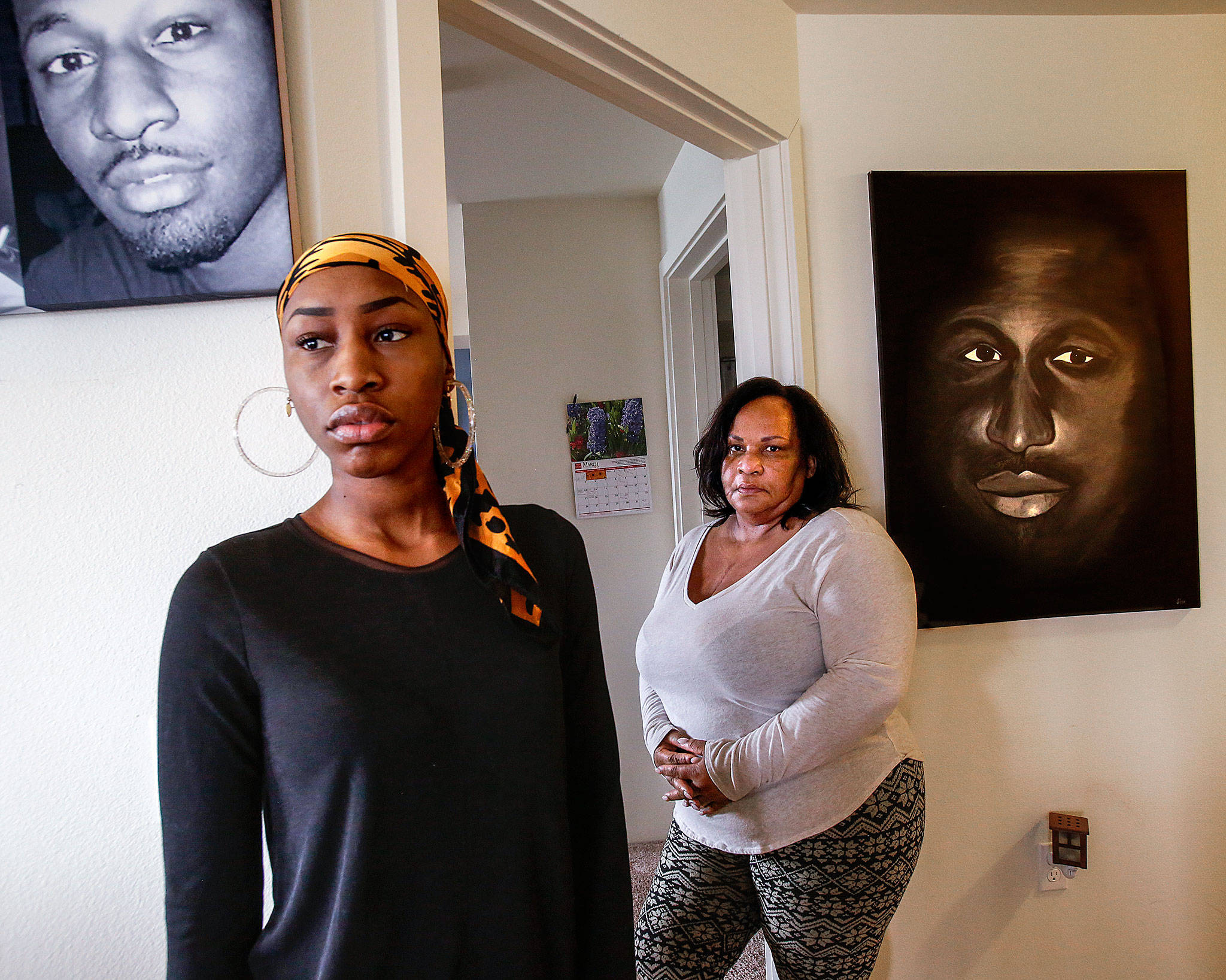 Youngest daughter, Rhonda Faison, 28 (left) and her mom Patricia Faison meet at Patricia’s Lynnwood home, March 15 to talk about brother and son, Henry Faison, depicted in photo (top) and painting by Jason Fox (right). (Dan Bates / The Herald)