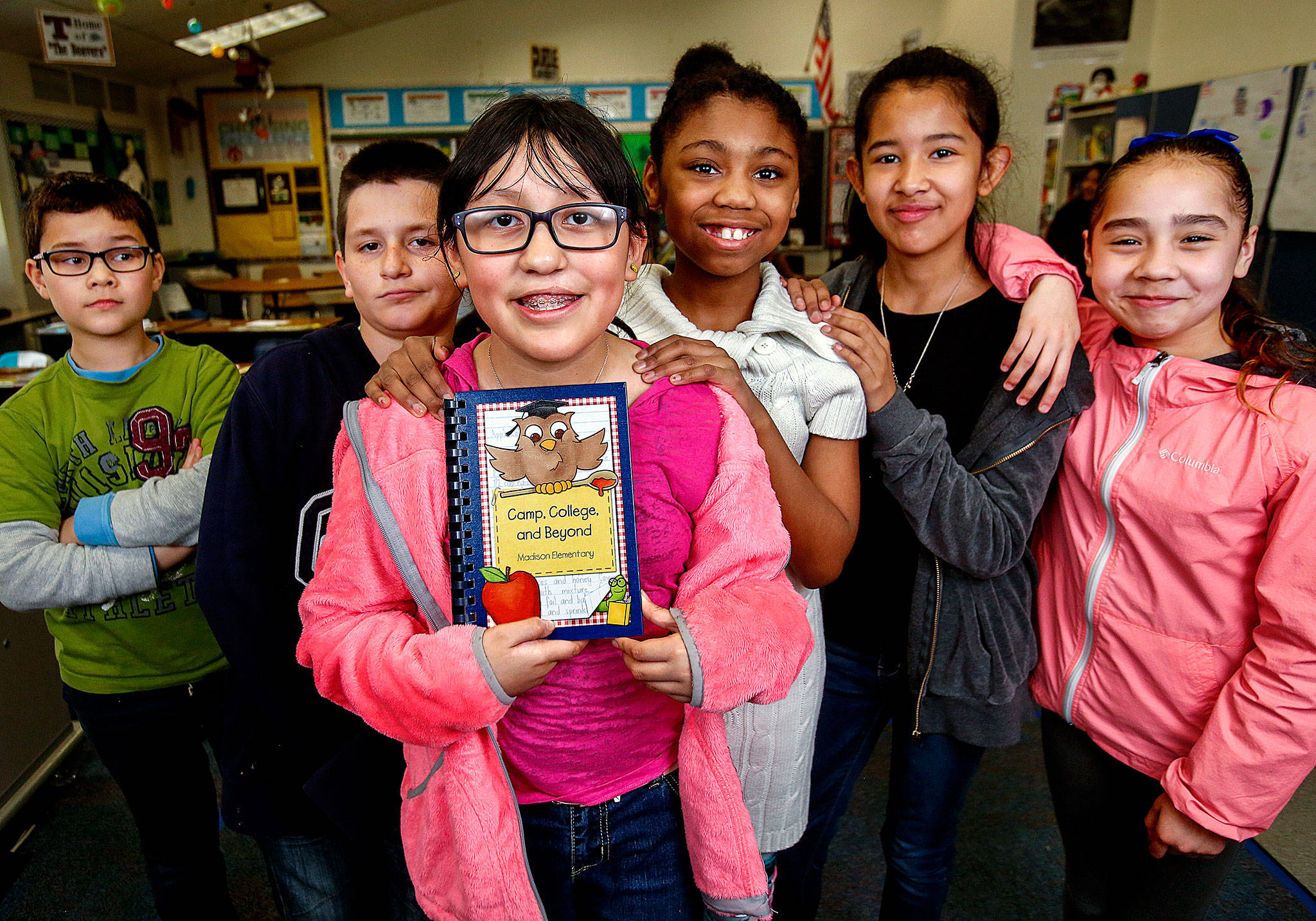 Along with their Madison Elementary School classmates, Jaedin Chum (left), Alfonso Moreno, Jaimy Moreno, Jaila Snowden, Daisy Padilla and Julissa Lopez are selling cookbooks with recipes from their teachers and parents to help pay their way to Camp Orkila on Orcas Island for fifth-grade outdoor camp. Jaimy Moreno, holding the cookbook (center), is tied with one other fifth-grader in sales thus far. (Dan Bates / The Herald)