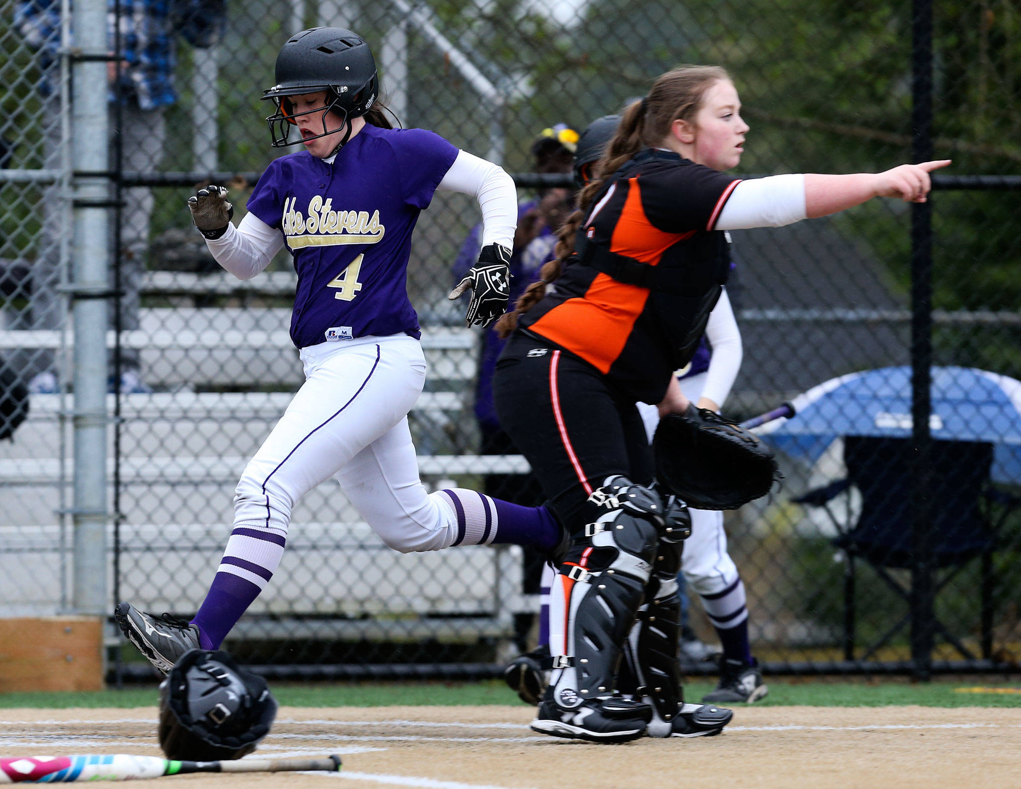 Lake Stevens’ Camryn Dubois scores a run as Monroe’s Taylor Durant points to second base during Monday’s game in Lake Stevens. (Andy Bronson / The Herald)