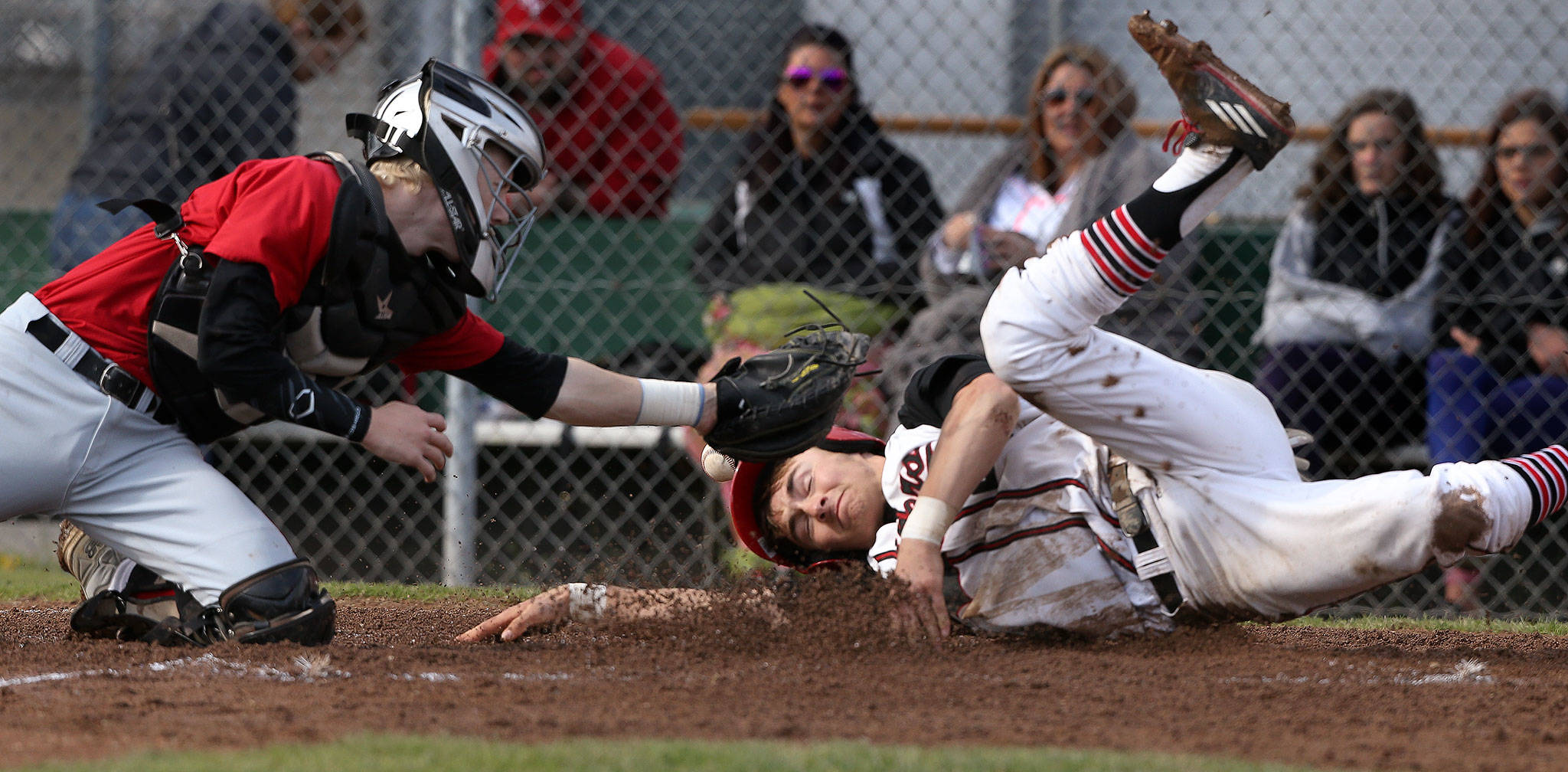 Snohomish’s Josh Johnston beats the tag at home by Marysville Pilchuck catcher Jordan Luton during a game April 18, 2017, in Snohomish. (Andy Bronson / The Herald)