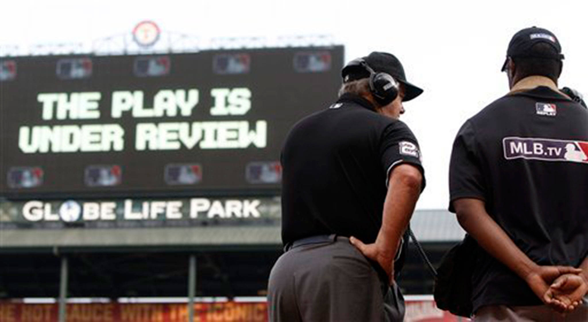 Umpire Joe West (22) communicates with MLB’s review command center in New York during a game last May between the Texas Rangers and the Cleveland Indians. (AP Photo/Brandon Wade)
