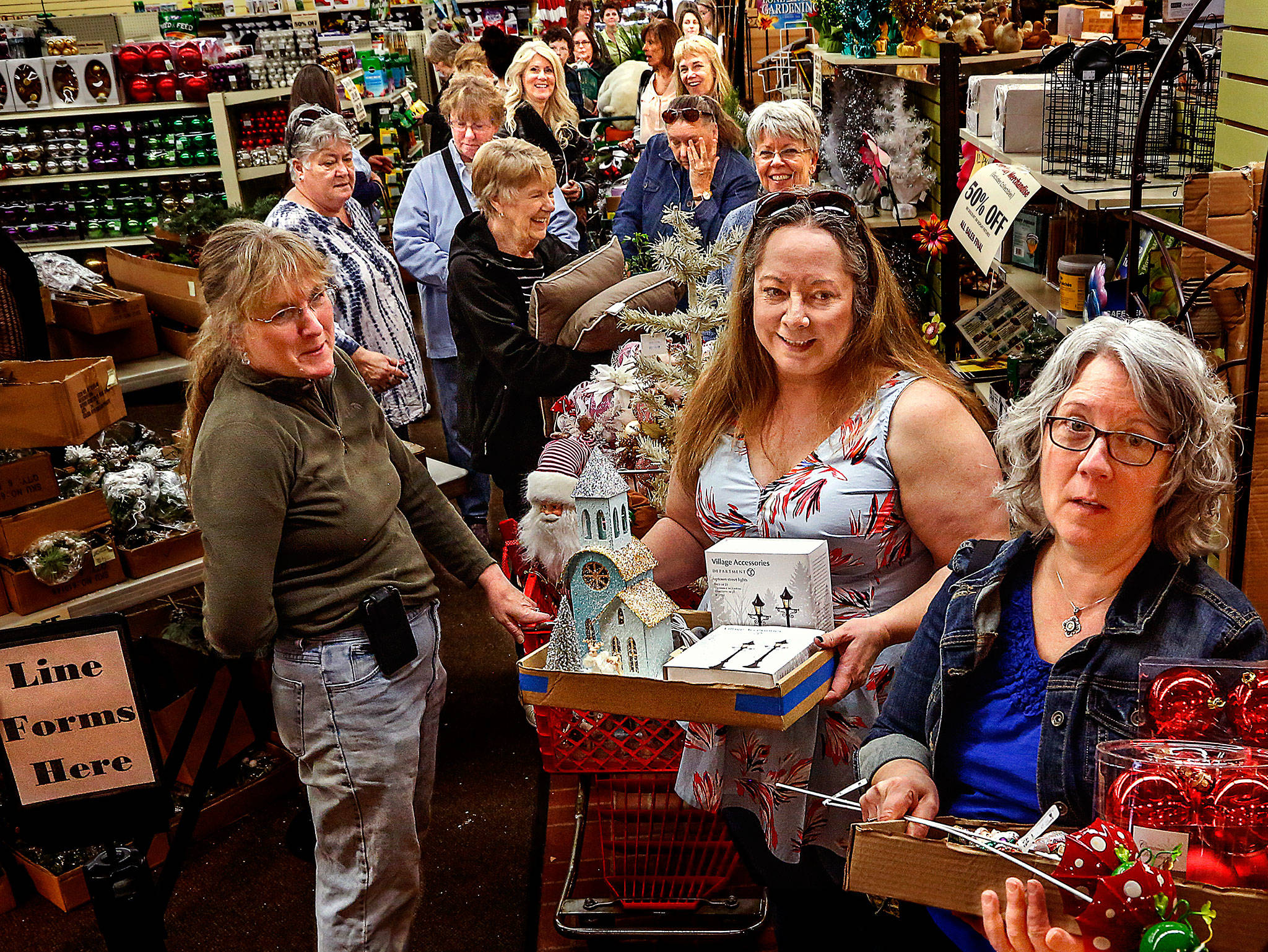 Bearing real treasure from a great store holding their biggest and last sale ever, Monika Clough of Edmonds (left), Angie Hoffman of Smokey Point and Tami McKinley of Mountlake Terrace finally near the check out counter Friday at Wight’s Home & Garden in Lynnwood. (Dan Bates / The Herald)