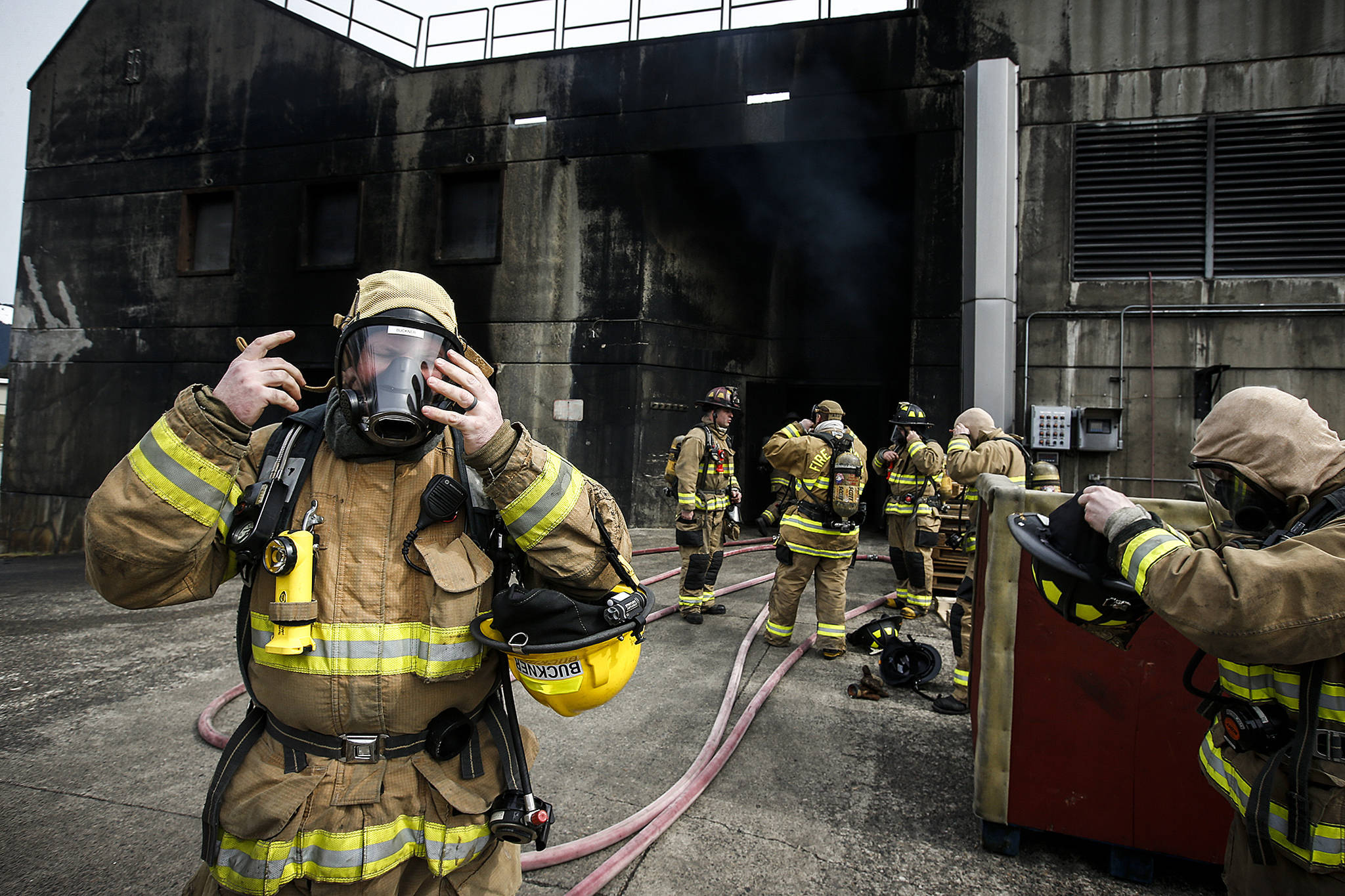 Photos by Ian Terry / The Herald                                Allen Buckner (left), a new Lynnwood Fire Department firefighter, adjusts his oxygen mask before beginning a training session at the Washington State Fire Training Academy near North Bend on Tuesday.