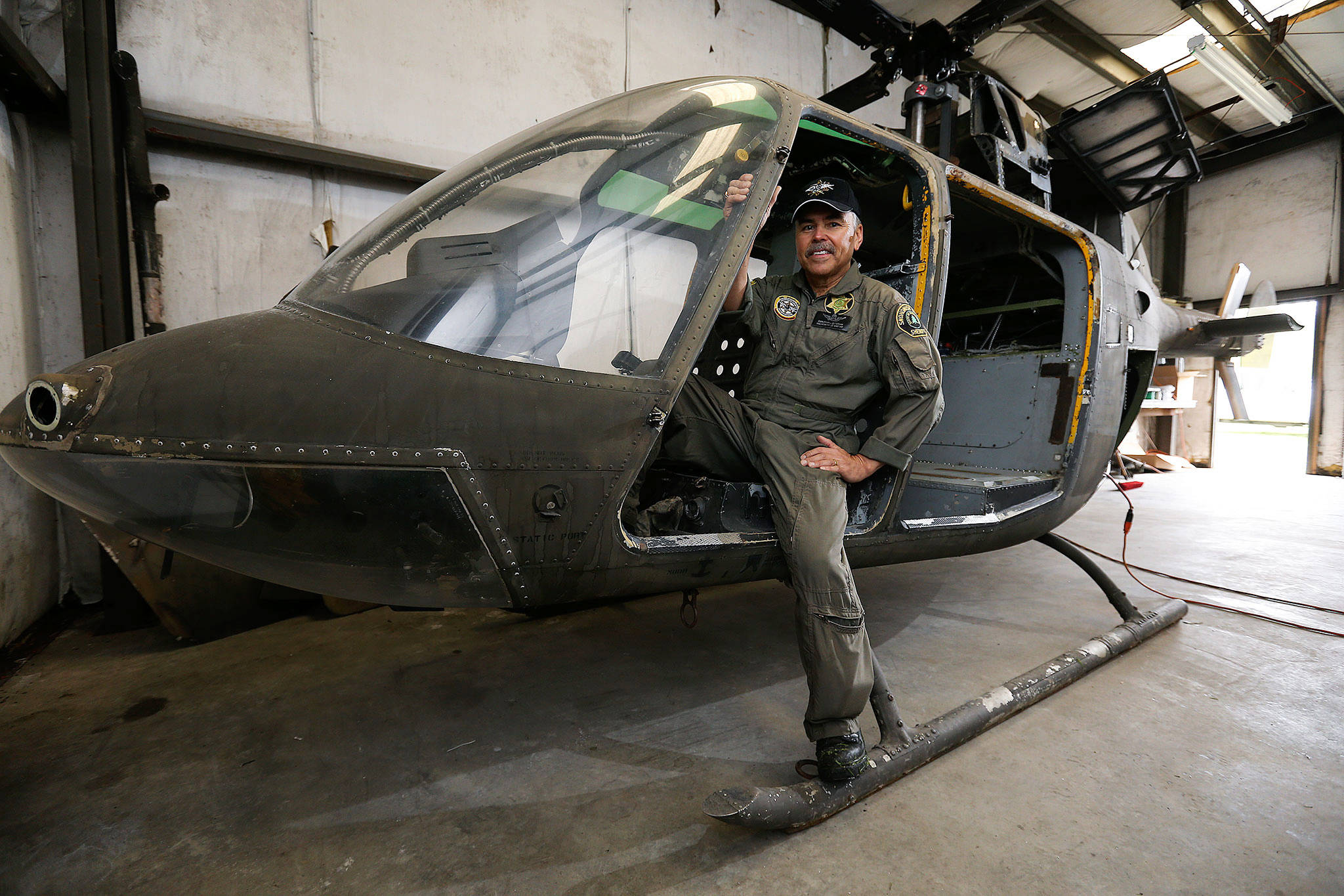 Snohomish County Sheriff’s Search & Rescue chief pilot Bill Quistorf sits in the stripped-out body of Kiowa helicopter April 19 in Snohomish. Search & Rescue is turning an old helicopter body into an outdoor-safety display for fairs and festivals. (Andy Bronson / The Herald)