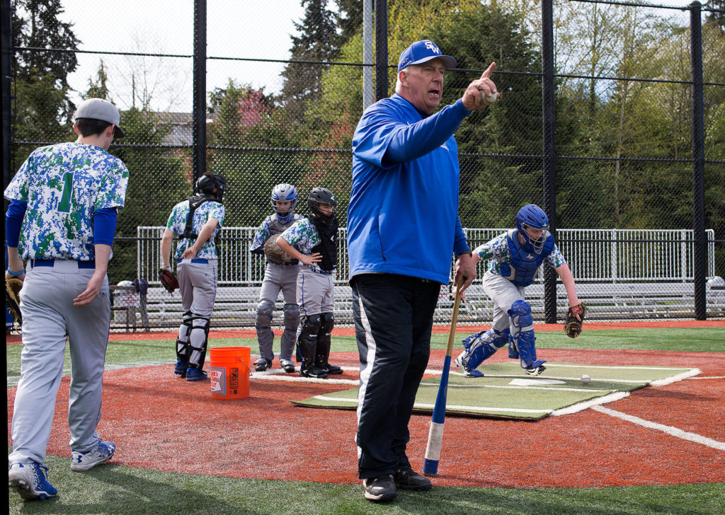Shorewood head baseball coach Wyatt Tonkin gives advice to a player in the infield as catchers practice behind him on Monday, April 24, 2017 in Shoreline, Wa. Tonkin reached his 300th win last week. (Andy Bronson / The Herald)
