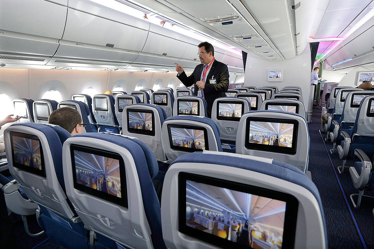 An Airbus employee describes the passenger cabin of a new Airbus A350 XWB passenger plane at Newark Liberty international airport in Newark, New Jersey, in 2015. Airbus says production delays persist on the twin-aisle A350. (AP Photo/Mel Evans)