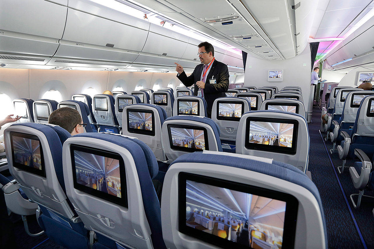 An Airbus employee describes the passenger cabin of a new Airbus A350 XWB passenger plane at Newark Liberty international airport in Newark, New Jersey, in 2015. Airbus says production delays persist on the twin-aisle A350. (AP Photo/Mel Evans)