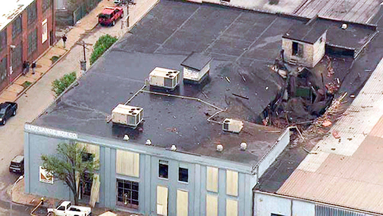 Damage to the roof of a box company in St. Louis after a boiler exploded and flew before crashing through the roof of a nearby laundry business. (KMOV via AP)