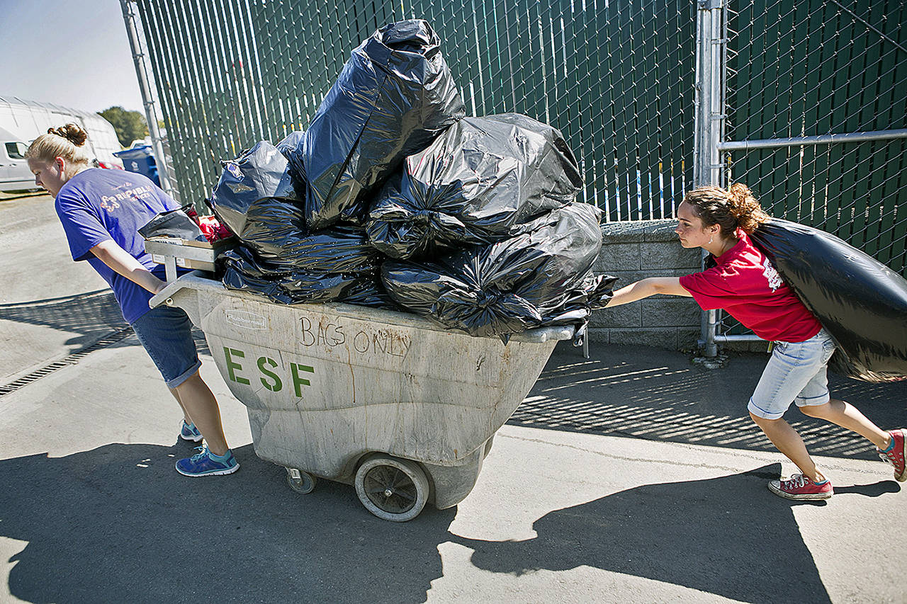 Madison Berry (left) and Zoie Miller hauled bags of garbage during the 2014 Evergreen State Fair. (Kevin Clark/ Herald file)