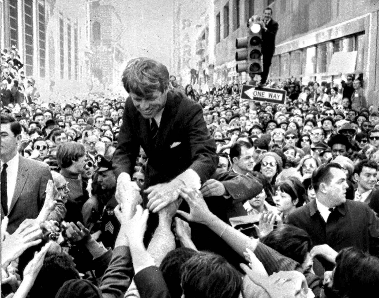 Senator Robert Kennedy is surrounded by hundreds of people as he leans down to shake hands during a campaign appearance at a street corner in central Philadelphia on April 2, 1968. (Associated Press)