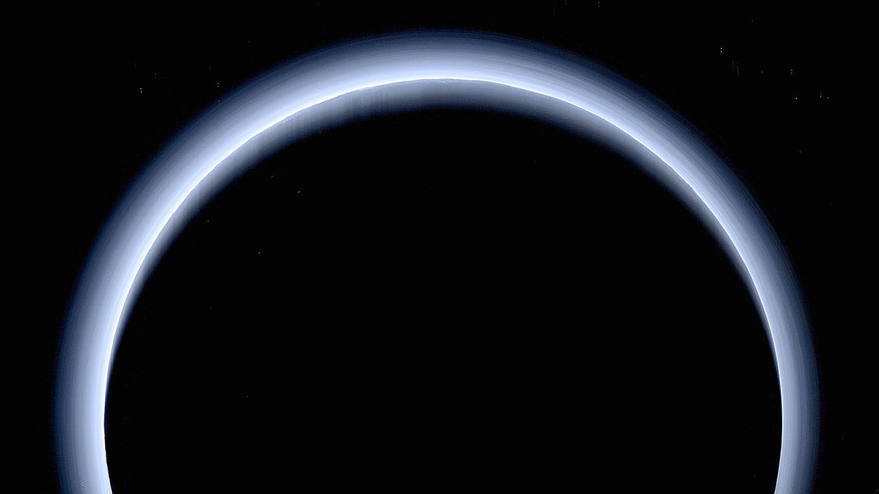 Pluto is illuminated from behind by the sun as the New Horizons spacecraft travels away from it at a distance of about 120,000 miles. (NASA)