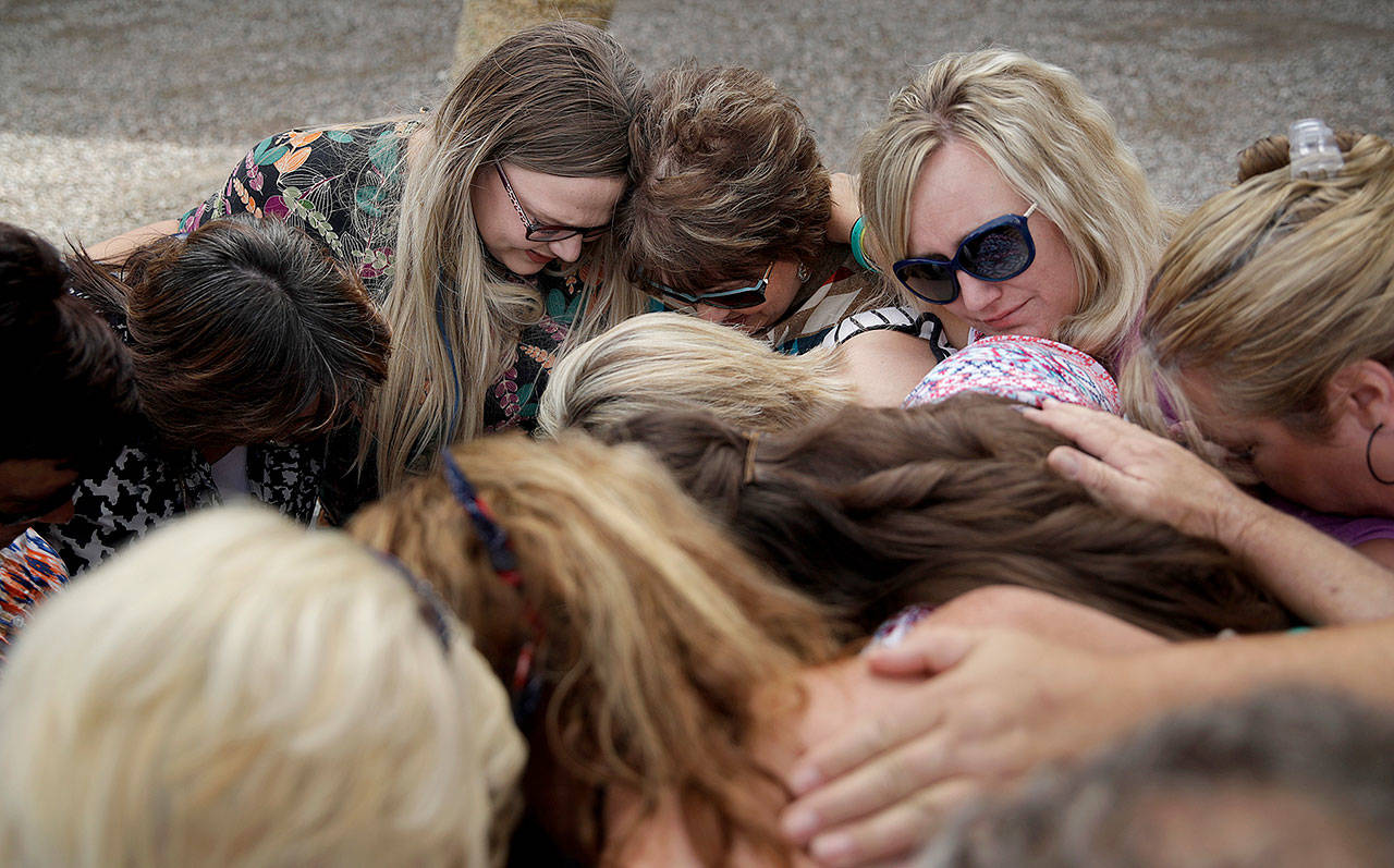 People including Carol Bundy (top center), wife of Nevada rancher Cliven Bundy, embrace after a partial verdict outside of the federal courthouse on Monday in Las Vegas. A jury found two men guilty of federal charges in an armed standoff that stopped federal agents from rounding up cattle near Cliven Bundy’s Nevada ranch in 2014. (AP Photo/John Locher)