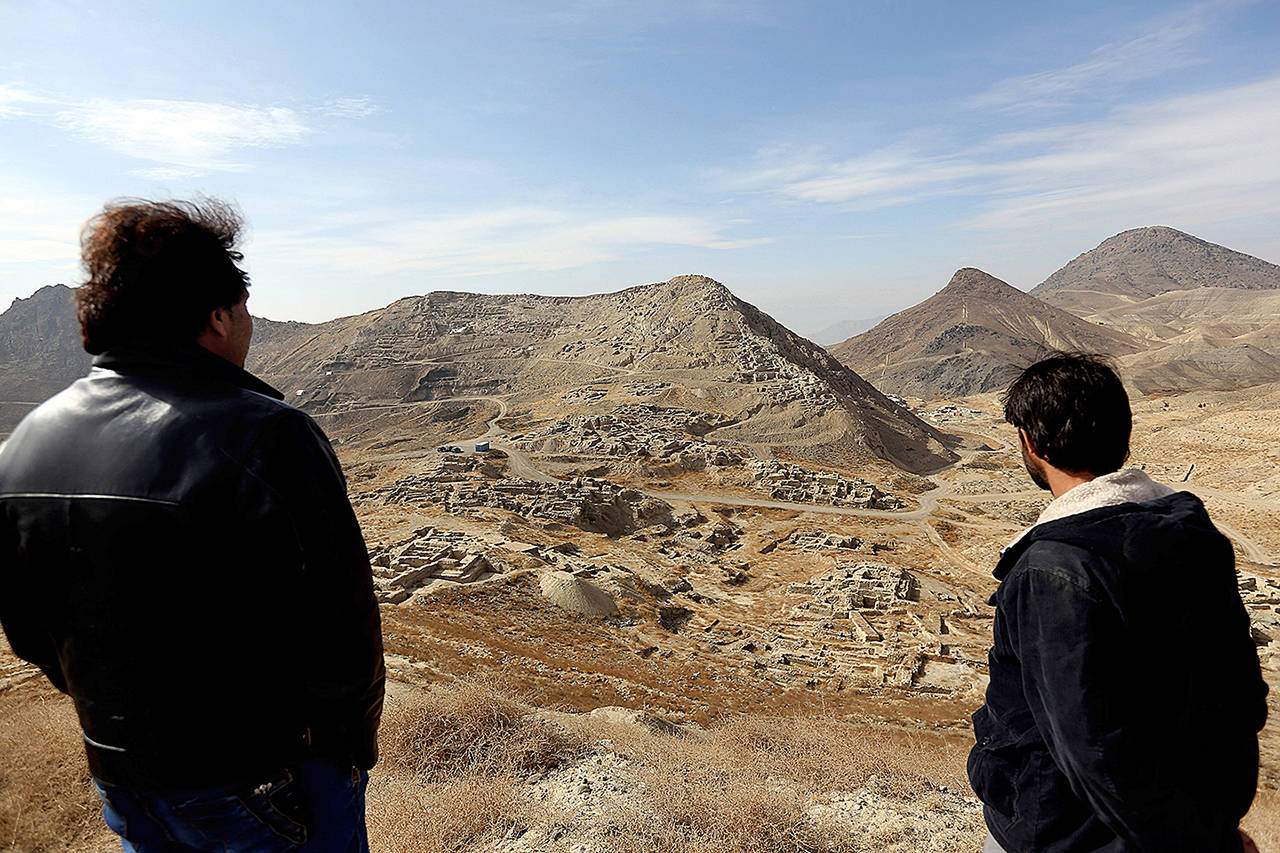 In this 2015 photo, Abdul Qadir Timor (left), director of archaeology at the Ministry of Information and Culture, looks at the view of Mes Aynak valley, some 25 miles southwest of Kabul, Afghanistan. (AP Photo/Rahmat Gul, file)