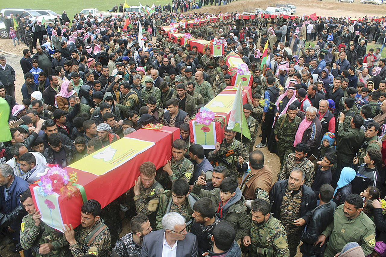 This photo shows fighters from the predominantly-Kurdish Syrian Democratic Forces carrying the coffins of their comrades, who were killed Tuesday by a misdirected airstrike by the U.S.-led coalition, during their funeral procession, in Tal al-Abyad, northeast Syria, on Thursday, April 13. (Hawar News Agency via AP)