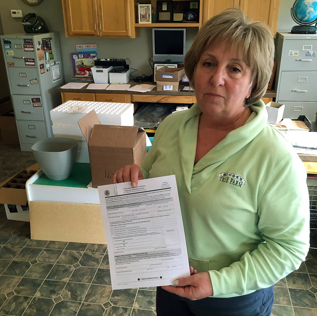 Kathy LeCompte, owner of Brooks Tree Farm near Salem, Oregon, shows an I-9 form of Employment Eligibility Verification on March 2 at her farm. Her employees, most of them Latinos, must fill out the form. Farmers, nursery and winery owners and others who depend on immigrant labor are predicting a catastrophe as federal immigration agents focus on stepping up arrests of people who are in America illegally. (AP Photo/Andrew Selsky)