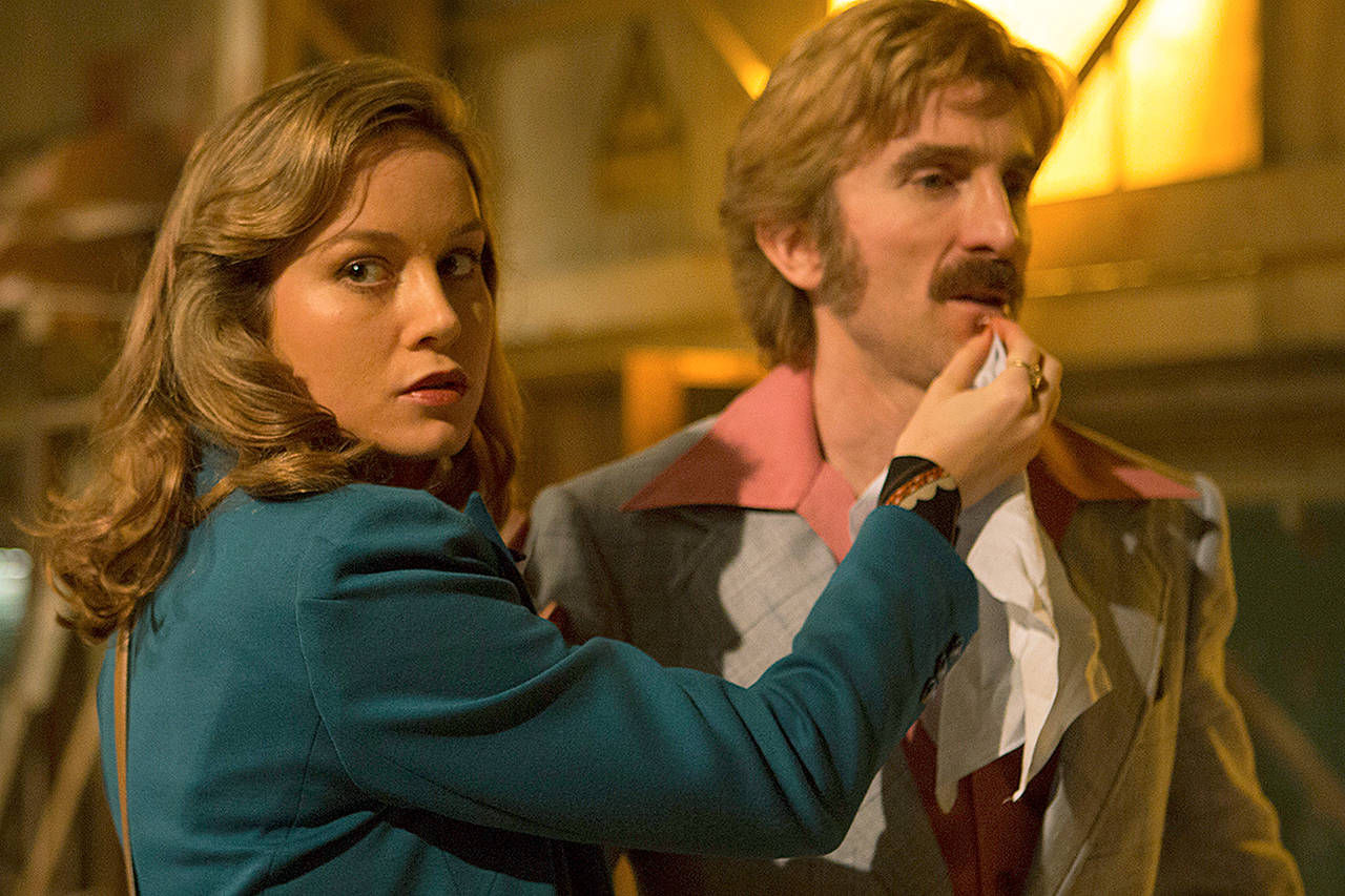 A meeting in a deserted Boston warehouse between two gangs turns into a shootout and a game of survival in “Free Fire,” starring Brie Larson (left) and Sharlto Copley. (Kerry Brown/A24 via AP)