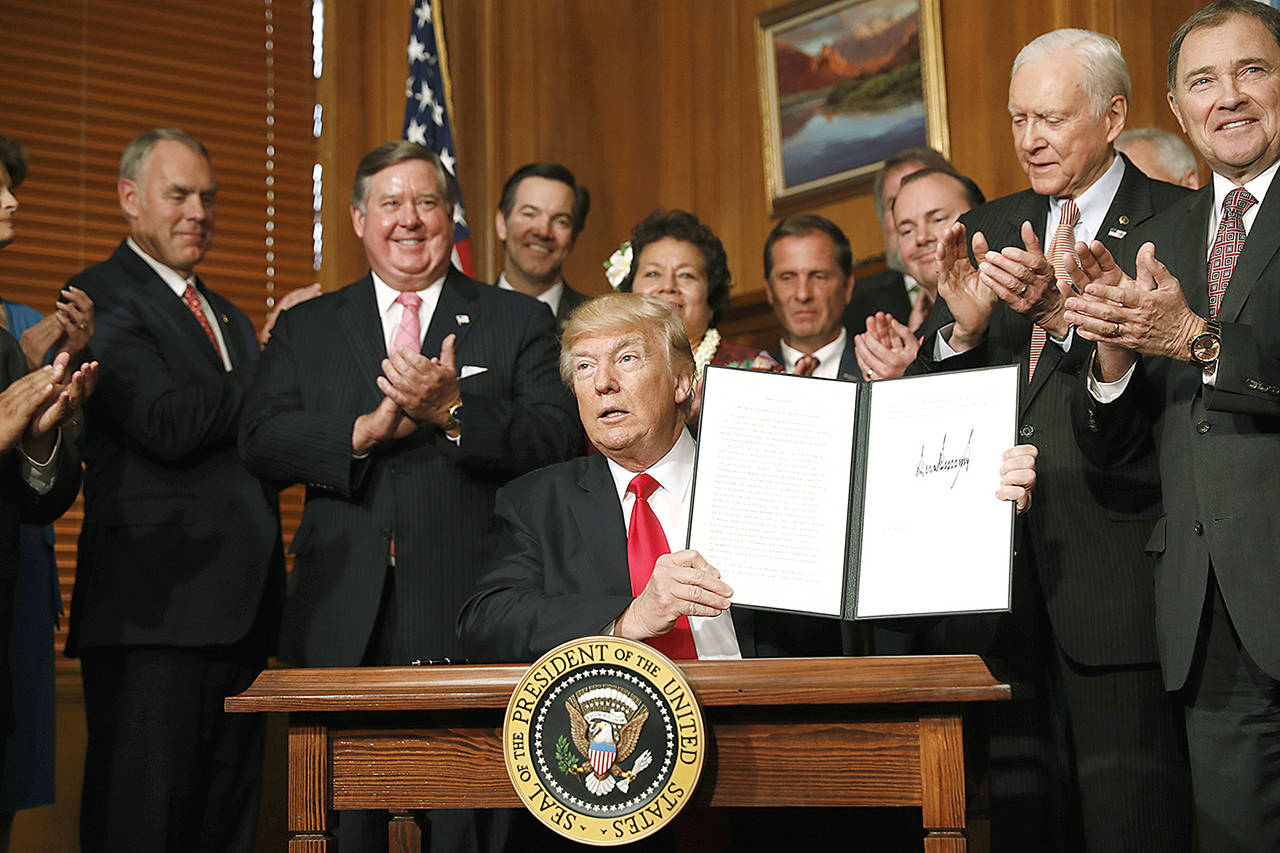 President Donald Trump holds up a signed Antiquities Executive Order during a ceremony at the Interior Department in Washington on Wednesday, April, 26. The president is asking for a review of the designation of tens of millions of acres of land as “national monuments.” (AP Photo/Carolyn Kaster)