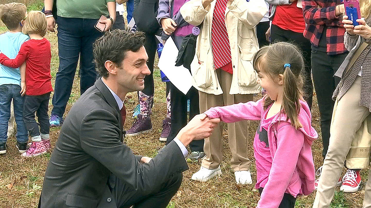 In a March 27 photo, Democratic congressional candidate Jon Ossoff is seen with supporters outside of the East Roswell Branch Library in Roswell, Georgia, on the first day of early voting. (AP Photo/Alex Sanz)