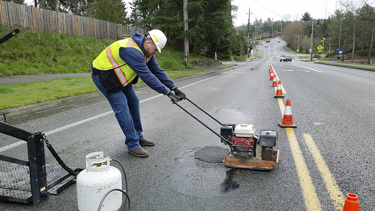 Mukilteo Public Works worker Jamieson McDaniels patches a pothole last month. Crews have been busy patching potholes on a near-daily basis. The city, like others, is seeing more potholes than usual due to the region’s severe winter weather. Cold patches like this one are a temporary fix until warmer temperatures allow for more permanent hot asphalt fills. (Contributed photo)