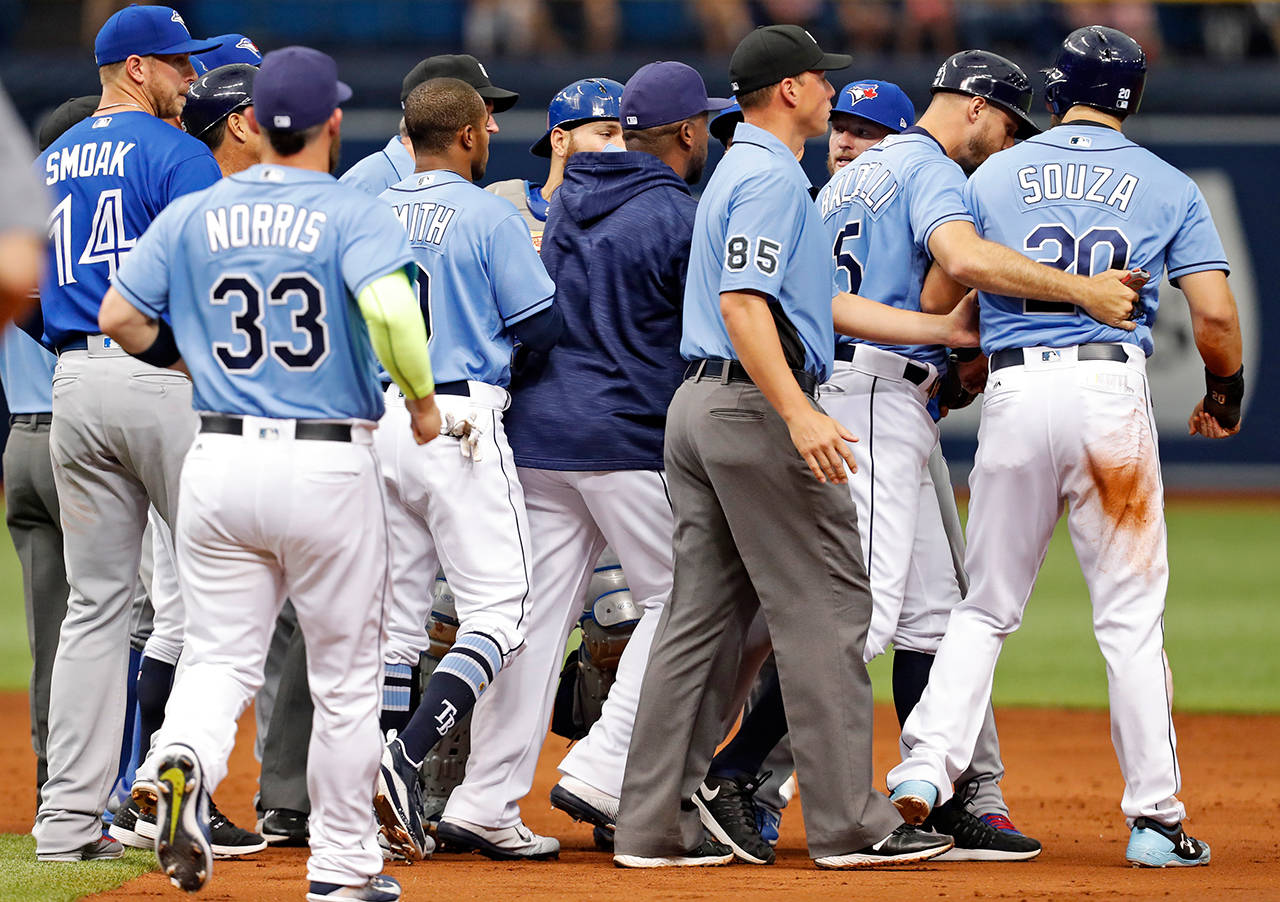 Tampa Bay Rays first base coach Rocco Baldelli, second from right, holds back Steven Souza Jr. as members of the Tampa Bay Rays and Toronto Blue Jays clear the benches following Souza Jr.’s slide into second base during the second inning of a baseball game, Sunday, April 9, 2017, in St. Petersburg, Fla. (AP Photo/Mike Carlson)