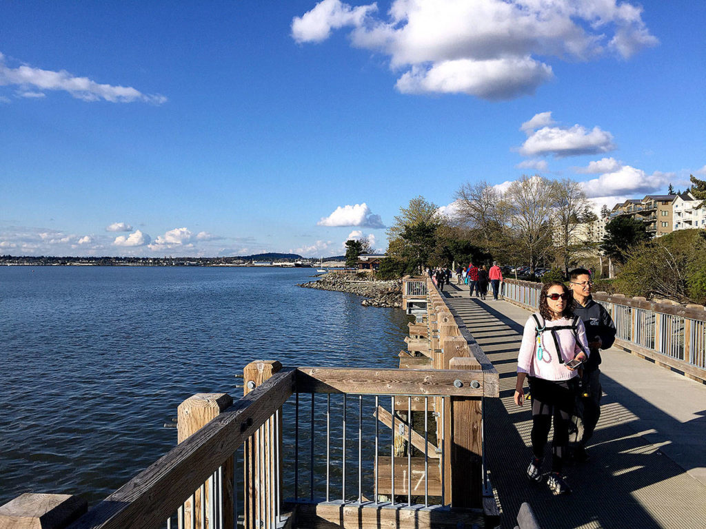 Visitors stroll along the overwater boardwalk at Boulevard Park in Bellingham. The boardwalk serves as the last quarter mile of the South Bay Trail. (Aaron Swaney photo)
