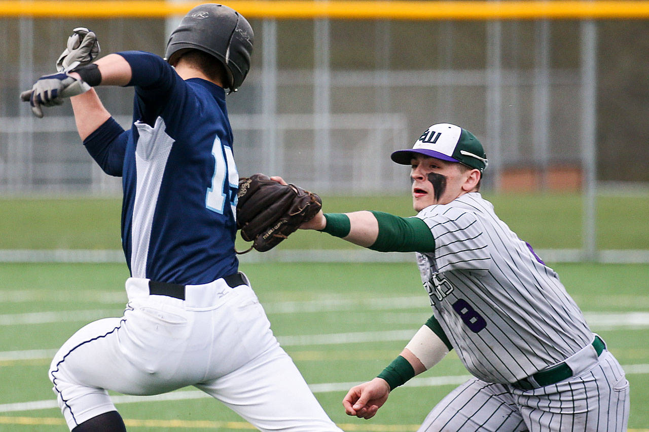 Edmonds-Woodway’s Kosta Cooper (right) tags out Meadowdale’s Hunter Shouse during a game April 12, 2017, at Mountlake Terrace High School. (Kevin Clark / The Herald)