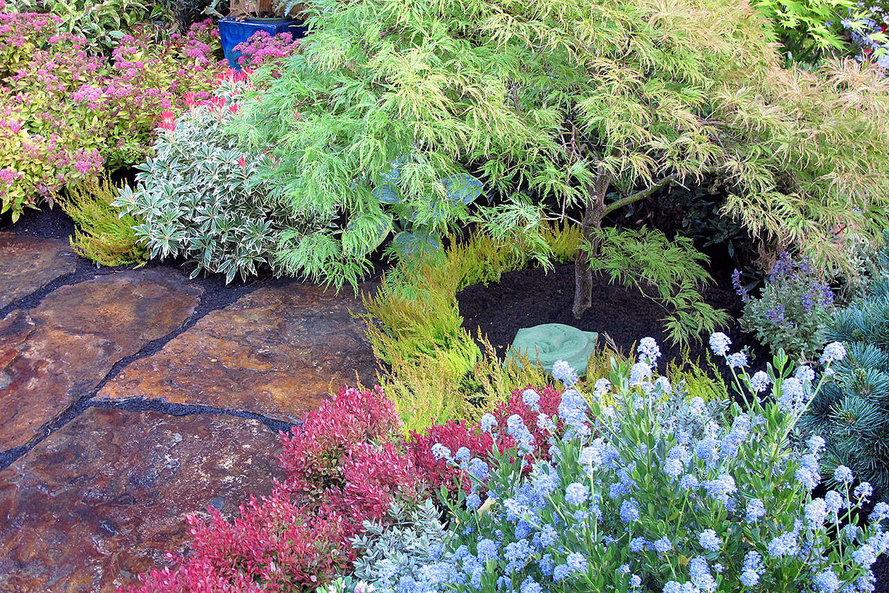 A flagstone path in a local garden is lined with colorful plantings. Set them close together for a tiled look or a few inches apart for stepping stones. (Pam Roy photo)